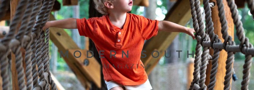 Small child climbs through a ropes course